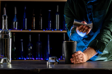 Bartender's hands serving cocktails on bar counter in a restaurant, pub. Mixed drinks. Alcoholic cooler beverage at nightclub on dark background