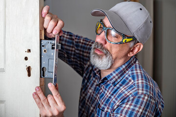 Door lock installation, repair, or replacement service. Door hardware installer locksmith working...