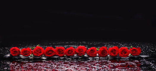 Still life of with 
red rose with zen black stones on wet background
