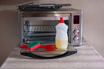 Dirty oven electric oven and items for washing and cleaning detergent sponge brush. High quality photo