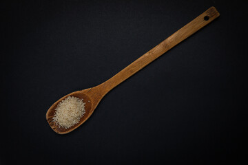 wooden spoon with salt and spices on a dark background
