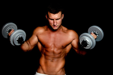 Naklejka na ściany i meble Young attractive sportsman with dumbbells. Male athletic body. 