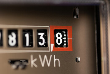 Close-up electricity meter. Analog gauge for households. Measuring the electricity consumed in kWh...