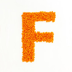 Capital letter F made from red lentils. Lentil font. White background. Bright font for menu or food blog. Lettering design element. Init cap
