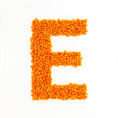 Capital letter E made from red lentils. Lentil font. White background. Bright font for menu or food blog. Lettering design element. Init cap