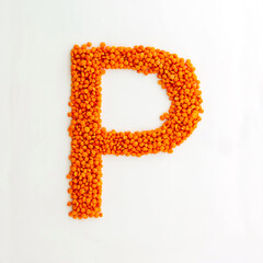 Capital letter P made from red lentils. Lentil font. White background. Bright font for menu or food blog. Lettering design element. Init cap
