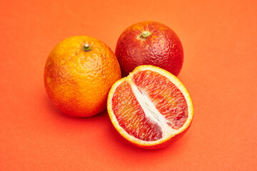 cut large juicy Sicilian oranges on an orange background. red orange pulp, blood oranges