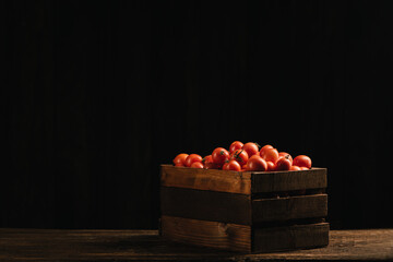 Fressh Red tomatoes box on wooden table.