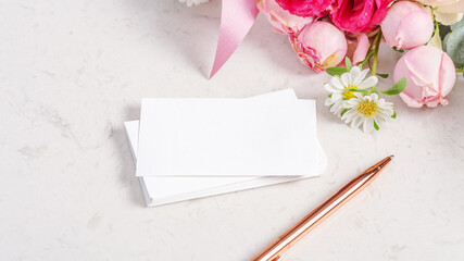 Greeting or invitation card mockup with flower and rose gold pen