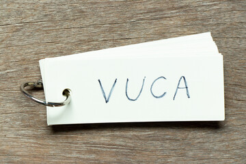 Flash card with handwriting word VUCA (abbreviation of Volatility, uncertainty, complexity and...