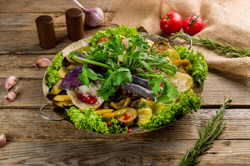 saj of lamb with greenery and fried vegetables on old wooden table