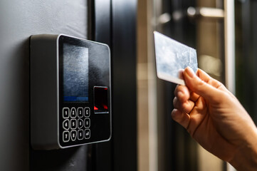 A woman opens the door with a plastic card. Modern keyless entry lock. 