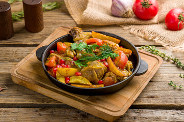 pan-fried chicken with potatoes on old wooden table