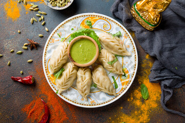 Indian food Momo with vegetables with mint sauce on dark blue table, indian kitchen top view