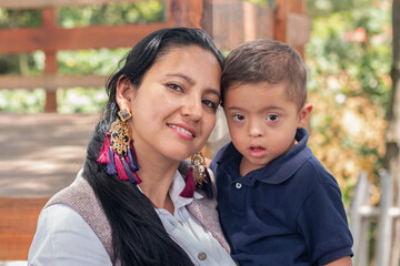 Portrait of a mother and her son with Down syndrome looking at the camera.Mother and child in a park