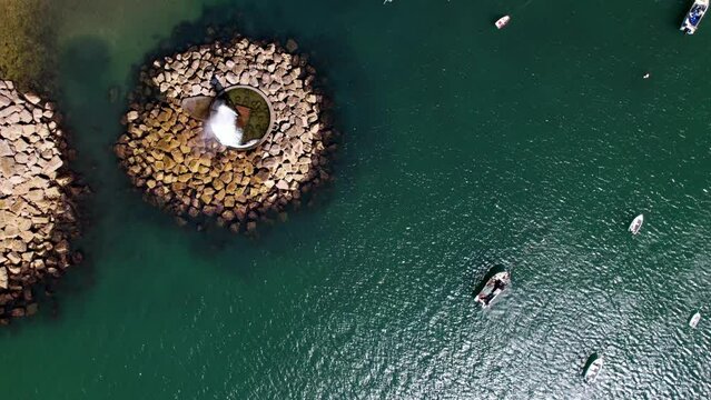 Top down spiral aerial view of geyster at Old Beach at Paco de Arcos bay in Oerias, Lisbon Region, Portugal
