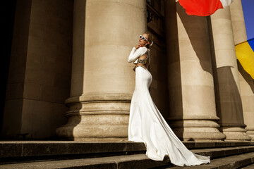 Elegant luxury fashion. Glamour, stylish elegant woman in long gown white dress is posing outdoor....