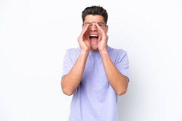 Young caucasian man isolated on white background shouting and announcing something