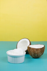 slice of fresh coconut and bottle of oil on a table 