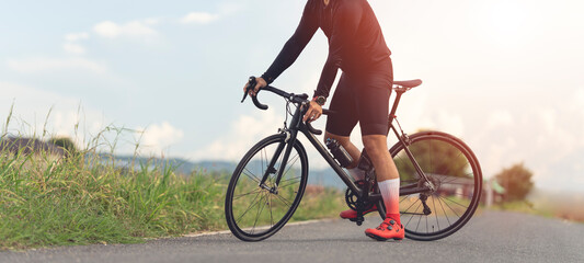 Professional cyclist in cycling training suit against green nature blur background Healthy fitness...