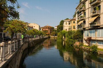 Fototapeta na wymiar The Sile River as it flows through the historic centre of Treviso in Veneto, north east Italy. View from the Via San Margherita bridge 