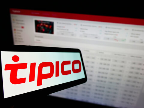 Stuttgart, Germany - 01-08-2022: Cellphone with logo of sports betting company Tipico Co. Ltd on screen in front of business webpage. Focus on left of phone display.