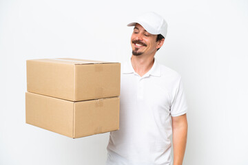 Delivery caucasian man isolated on white background looking to the side and smiling