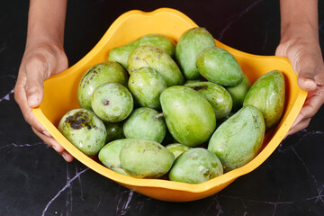Fresh green mango in a bowl on table 
