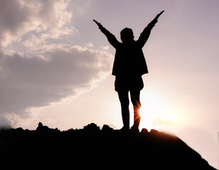 Silhouette of a woman praying over a beautiful sky. Hypnosis concept.