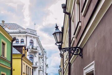 A beautifully decorated city lantern in the form of a wall lamp. Background out of focus. Zamość, Poland