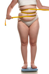 obesity and overweight, overweight woman legs and belly on the scale, holding mettering tape. concept of obesity - obrazy, fototapety, plakaty