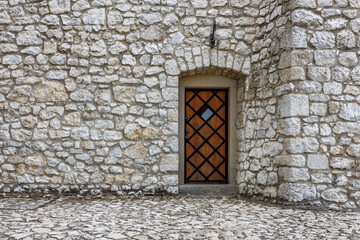 Średniowieczne drzwi z drewna w kamiennym budynku. 
Wejście do starego świata. 