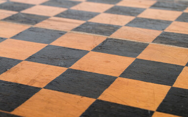 Fototapeta premium shabby surface of an old wooden chessboard, close-up