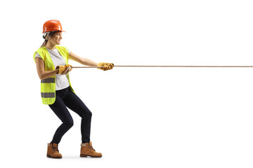 Full length profile shot of female engineer pulling a rope