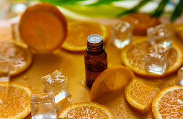 Essential oil of orange on a yellow background. Selective focus.