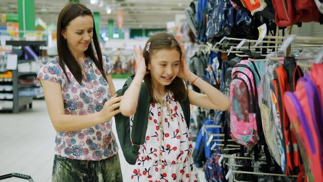 Mom tries on a new school backpack for her daughter before the new school year.