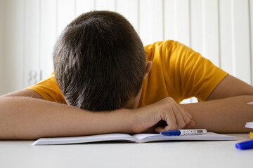 The boy fell asleep while doing his homework