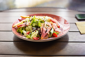 Vegetables and prosciutto crudo salad.Restaurant  meat fresh salad close up. Mediterranean seasonal side dish.