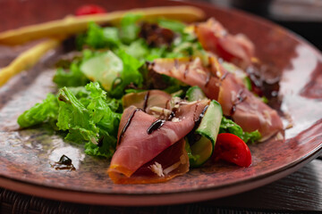 Vegetables and prosciutto crudo salad.Restaurant  meat fresh salad close up. Mediterranean seasonal side dish.