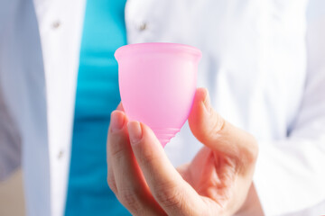 Fototapeta na wymiar menstrual cup in the hands of a gynecologist doctor. Menses,menstrual period, women's menstruation