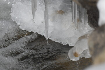 icicles hanging off a rock over a stream of melting snow on the Rocky Mountains