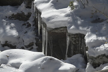icicles on a rock covered in snow on the Rocky Mountains 