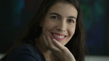 Portrait of woman in 30s smiling. Person face closeup looking at camera