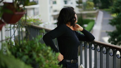 Confident woman standing at home balcony feeling happy. A joyful hispanic south american girl