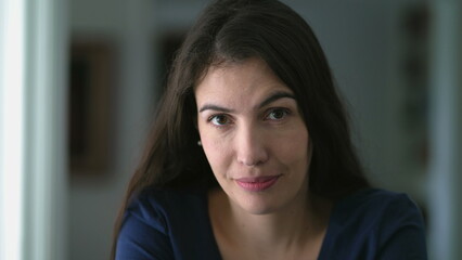 Fototapeta premium Portrait of a 30 year old woman face closeup no expression looking at camera