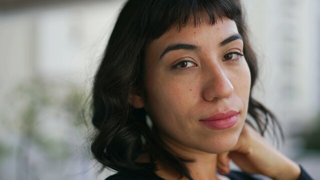 Portrait of a Brazilian young woman with serious expression looking at camera. Closeup face of hispanic latin person