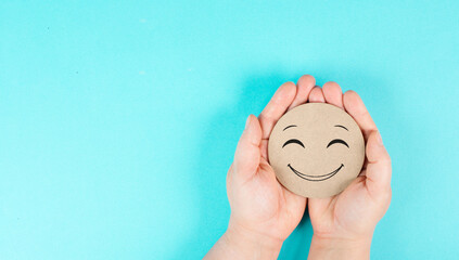Holding a smiling face in the hands, mental health concept, positive mindset, support and...