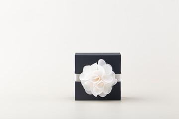 Side view of black isolated gift box with white ribbon