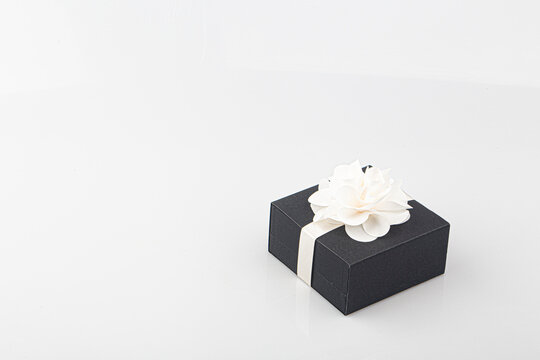 Side view of black isolated gift box with white ribbon