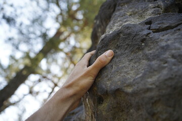 Hand grabbing a rock while bouldering (Saxon Switzerland, Germany).